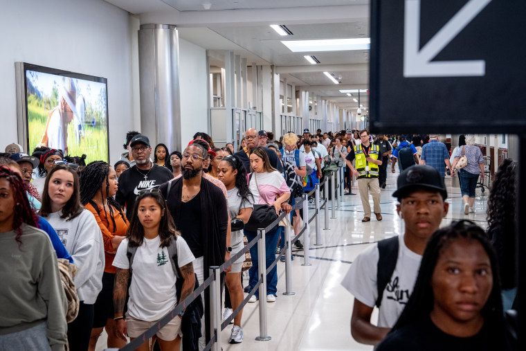 July 4 travel hitting new record thanks to lower gas prices, humming economy 1 Travelers stand in a long line