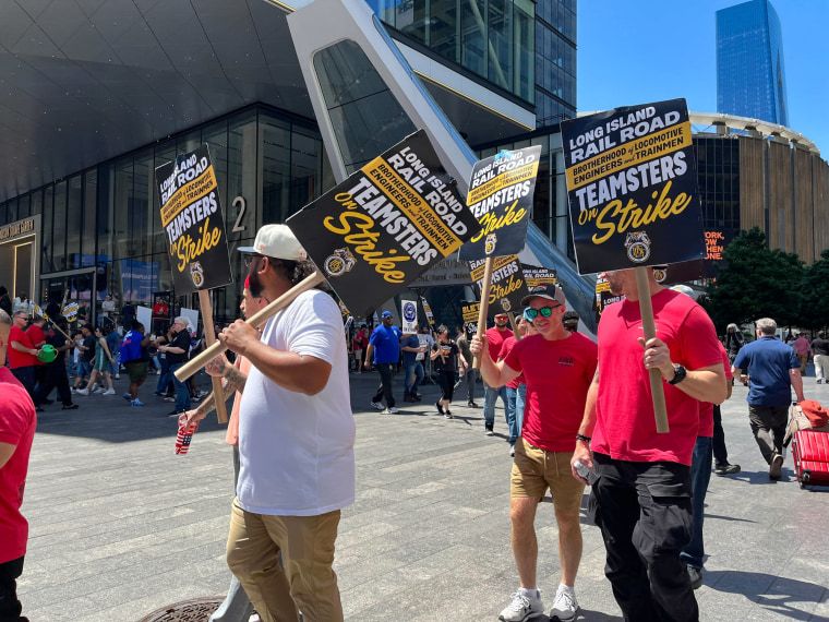 New York braces for chaotic Monday commute amid Long Island Rail Road strike 5 People hold picket signs proclaiming a strike while marching on the street outside