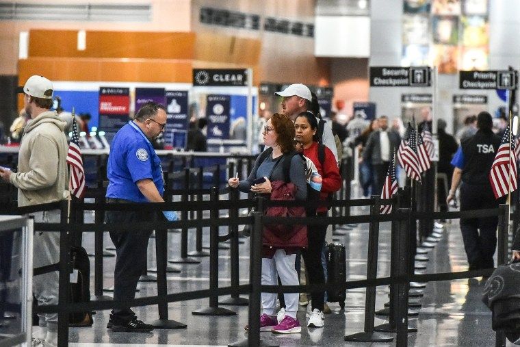Flight delays aren't slowing down despite move to end shutdown 1 Image: Travelers make their way through a security line