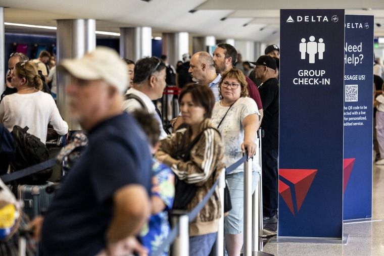 Delta cancels hundreds more flights as its recovery from global CrowdStrike-Microsoft outage lags 1 Image: Travelers wait in line at check-in in Terminal 2, Delta Airlines
