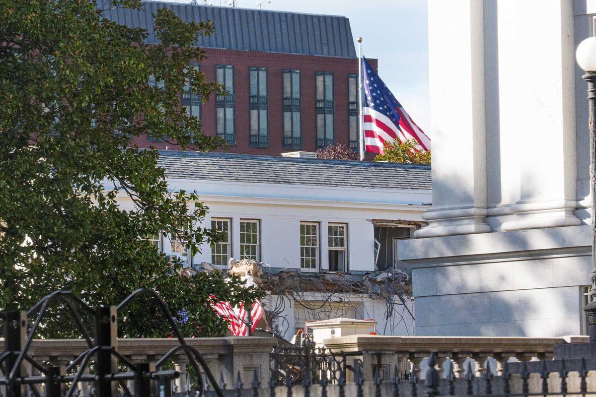 Video: White House Demolishes Facade of East Wing to Build Trump’s Ballroom 1 The partially demolished front of a building, with an American flag flying in the background.
