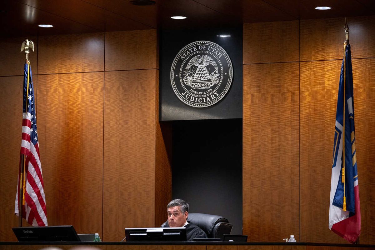 Video: Judge Decides to Keep Charlie Kirk Hearings Open to Public 1 Judge Tony Graf, wearing a dark robe, is seated at a desk in a formal, wood-paneled room. Two flags and a circular seal featuring that says “State of Utah Judiciary” are behind them.
