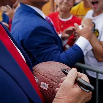 The Contests, Clubs and Big Promises of Trump’s Fund-Raising Emails 5 Promo image of a person in a blue suit holding a marker up to a signed football.